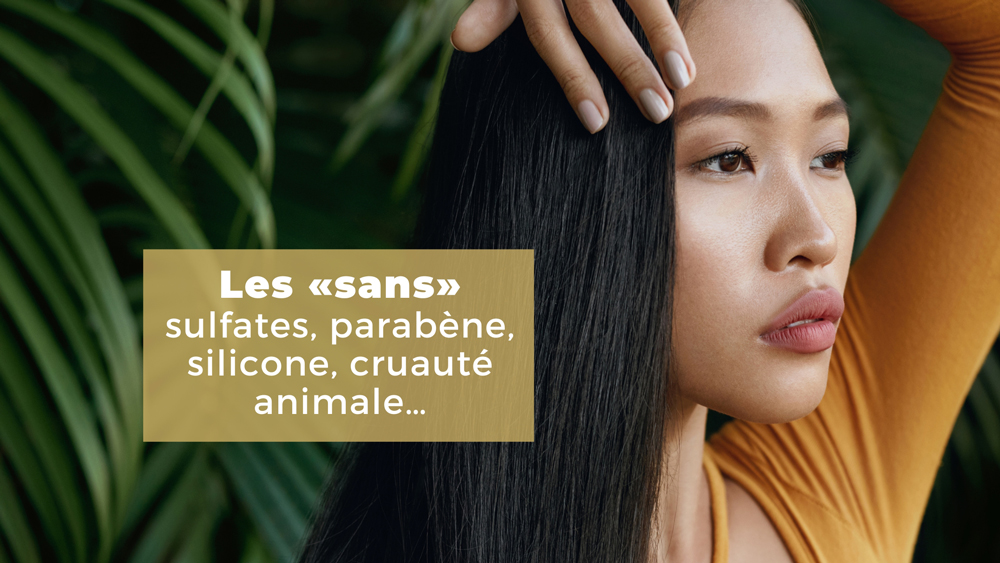 Femme aux longs cheveux noirs portant un chandail jaune avec des feuillages en arrière-plan